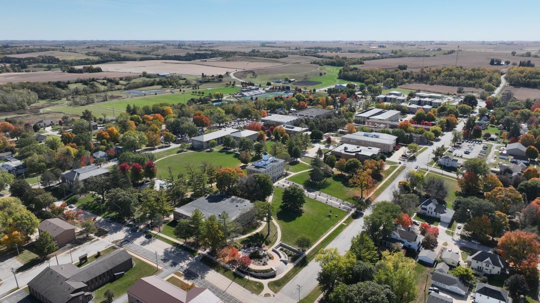  Arial view of Upper Iowa University's Fayette campus, with numerous academic buildings and rolling hills in the background